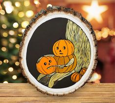 two pumpkins sitting on top of a tree stump in front of a christmas tree