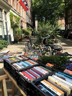 many books are on the table in front of some parked bikes and bicycles behind them