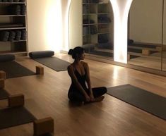 a woman is sitting on the floor in a yoga studio