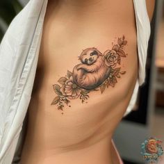 a woman's stomach with a slotty tattoo on her chest and flowers around it