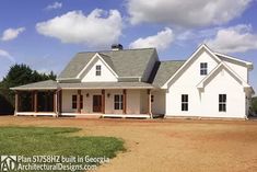 a large white house sitting on top of a dirt field