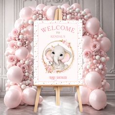 a welcome sign with pink balloons and an elephant in the center is surrounded by flowers