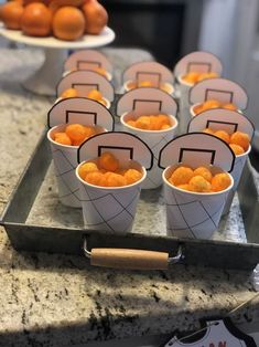 small cups filled with oranges sitting on top of a metal tray