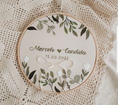 a personalized embroidered wedding ornament on a lace doily with flowers and leaves