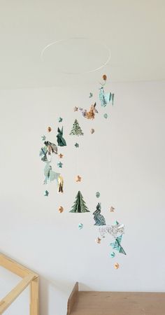 a baby crib next to a white wall with paper decorations hanging from the ceiling