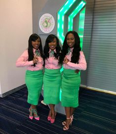 three women dressed in green and pink posing for the camera