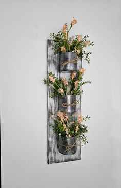 a wall hanging planter with flowers in it