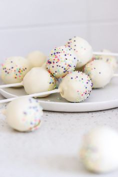 white cake pops with sprinkles on a plate