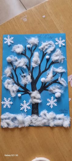 a paper plate with a tree on it and snow flakes all over the surface