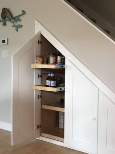 an under the stairs storage area with shelves and spice jars on it's sides