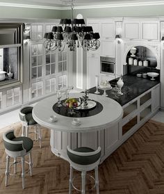 a large kitchen with white cabinets and an island in the center surrounded by bar stools