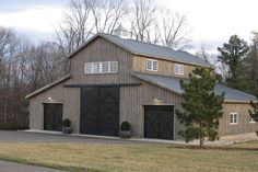 a large barn with two garages and three windows