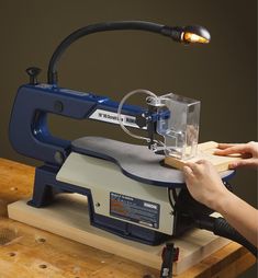 a person using a table saw to cut wood with a machine on top of it