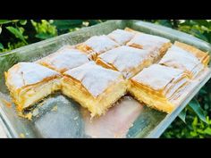 some food that is on top of a glass tray in the grass and trees behind it