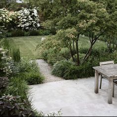 a wooden table sitting in the middle of a garden