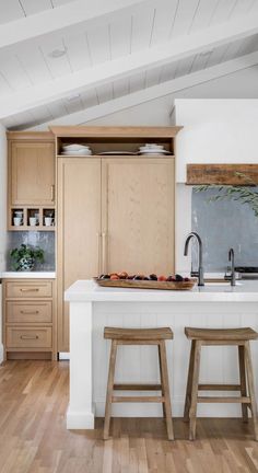 a kitchen island with two stools in front of it