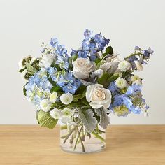 a glass vase filled with blue and white flowers