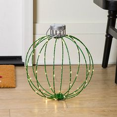 a metal ball with string lights sitting on the floor