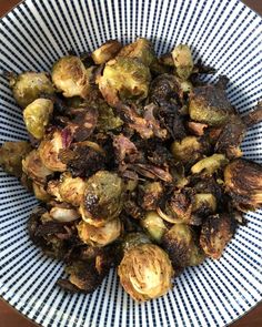 a blue and white bowl filled with brussel sprouts