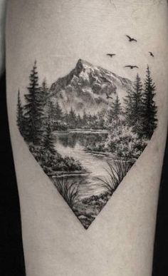 a black and white landscape tattoo on the leg