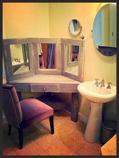 a bathroom with a sink, mirror and vanity in it's corner next to a toilet