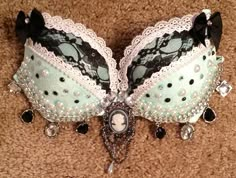 To complete: white bra, pink lace, black lace, black fabric bows, pearl studs, black studs, cameo button, silver sew on rhinestones, pearl beads, black rhinestone charms, silver rhinestone charms Bra Decorating Ideas, Bedazzled Bra, Decorated Bras, Sew On Rhinestones, Blue Lace Bra, Rave Fits, Diy Bra, Black Studs, White Bra