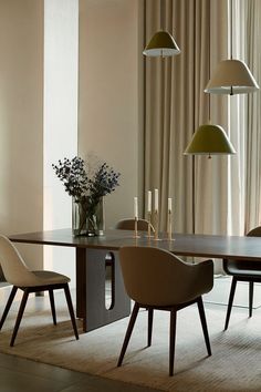 a dining room table with chairs and lamps