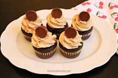 chocolate cupcakes with white frosting on a plate