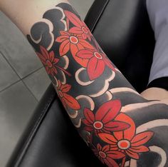 a woman's arm with red flowers on it