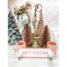 a santa clause figurine sitting on top of a counter next to coffee cups