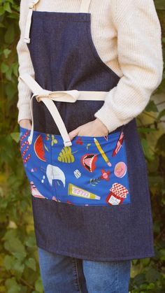 a woman is wearing an apron and has her hands in her pockets