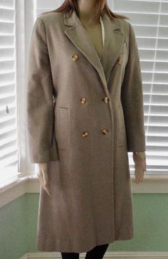 This is a Gorgeous Wool Coat. It is a long coat in a lightweight grayish beige wool blend with a long lapel and double breasted buttons. This coat has shoulder pads and slide in pockets with a gathered back mock belt that has side buttons for a detachable sash belt. The inside is fully lined in a rose sateen material. This fitted dress coat has just a few pin size moth nibbles and is in Excellent Condition! Label:    STEVEN FORSTMANN   Size:       Small 4 Petite (Double Check Measurements).  Measurements are taken with the garment LAYING FLAT. DOUBLE where applicable. Shoulder to Shoulder:     15" Sleeve Length:                 21" Armpit to Armpit:            17" Waist:                                 16" Hips:                                  17" Length From Back Collar:  40" Model Measu Cheap Double-breasted Outerwear With Button Cuffs, Luxury Double-breasted Pea Coat With Button Cuffs, Luxury Vintage Pea Coat With Double Button Closure, Luxury Fitted Pea Coat With Double-breasted Buttons, Luxury Double Button Pea Coat, Luxury Long Sleeve Pea Coat With Double Button Closure, Luxury Pea Coat With Double-breasted Button Fastening, Luxury Double-breasted Pea Coat With Buttons, Full Length Coat