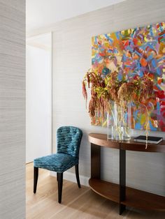 a blue chair sitting in front of a table with vases on top of it