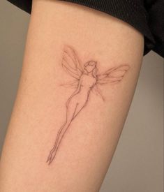 a woman's leg with a tattoo on it that has a small fairy sitting on top of it