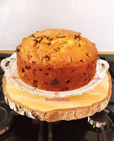 a cake sitting on top of a white plate next to a wooden slice of wood