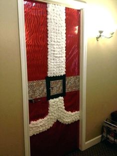 a door decorated for christmas with santa's hat and belt hanging on the side