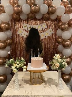 a birthday cake sitting on top of a table in front of balloons and streamers