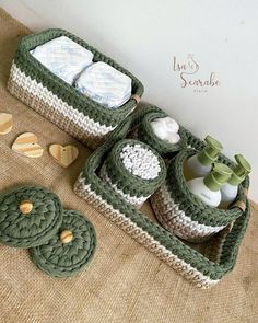 a crocheted bag with two baby items in it and some cookies on the ground