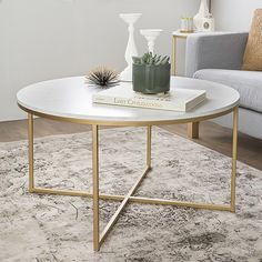 a living room with a couch, coffee table and vases on the rug in front of it