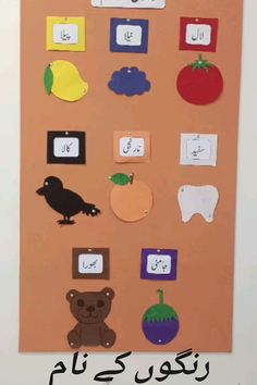 a bulletin board with arabic writing and pictures on the front, including an owl, bear, tomato, pear, lemons