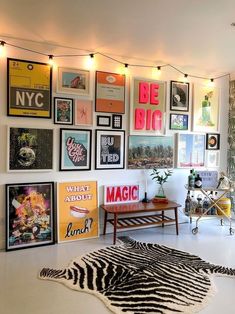 a living room filled with lots of pictures and posters on the wall above a zebra rug