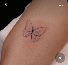 a small butterfly tattoo on the right arm and shoulder, it appears to be in black ink