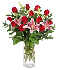 a vase filled with red roses and pink lilies