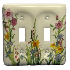 a decorative light switch cover with flowers painted on the front and back of each outlet