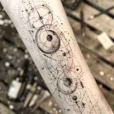 a person with a tattoo on their arm that has planets and stars all over it