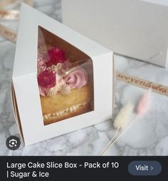 an image of a cake in a box with flowers on the top and other items around it