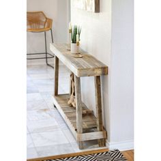 a wooden table sitting in front of a mirror on top of a wall next to a rug