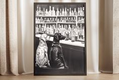 a black and white photo of two dogs sitting in front of a bar with liquor bottles