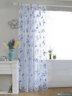 a white and blue curtain with flowers on it