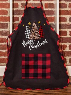 an apron hanging on a brick wall with the words merry christmas written in white letters